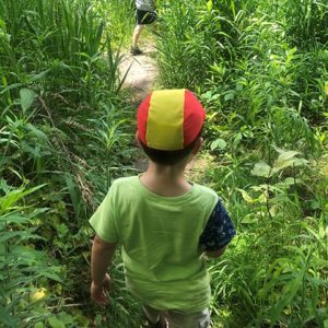 Preschooler hiking through grass